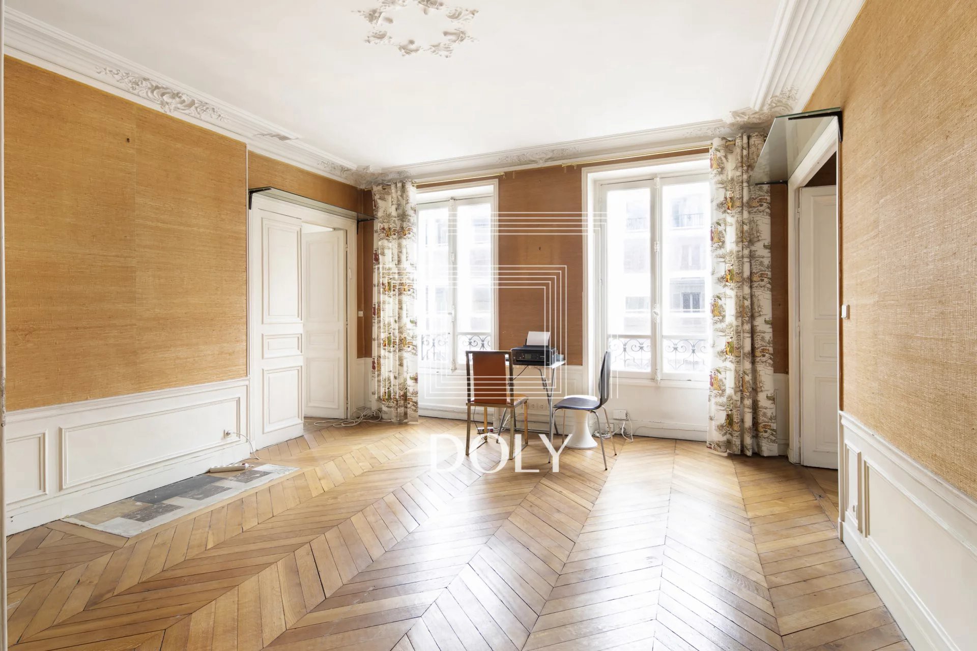 Appartement 5 pièces de 112 m² / 75008 - L'espace de vie, avec ses magnifiques finitions traditionnelles et son parquet en point de Hongrie, est très spacieux et bénéficie de deux grandes baies vitrées laissant entrer la lumière naturelle.