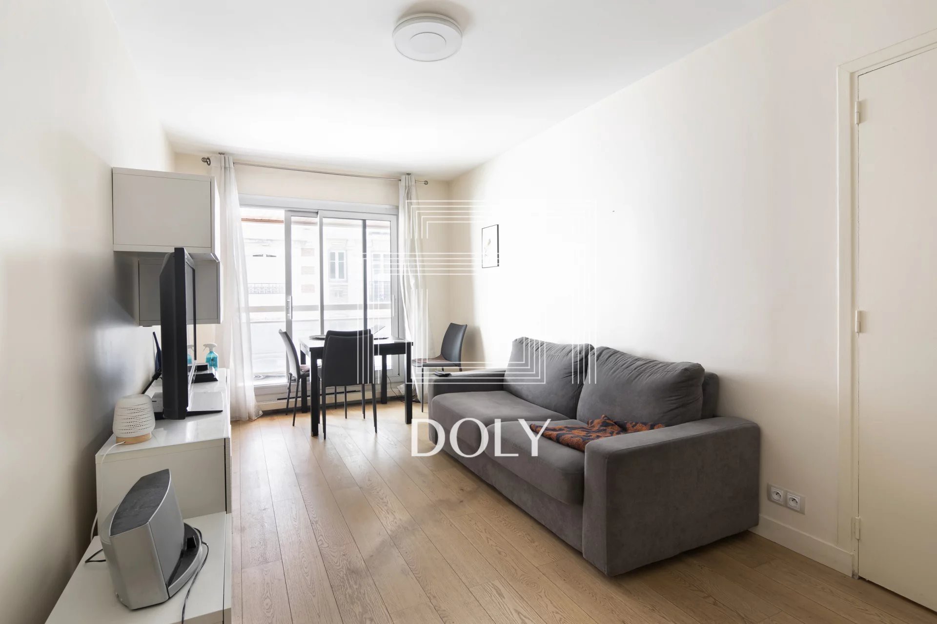 Appartement 2 pièces // Rue Vineuse // Paris XVIe - L'image montre l'espace de vie de l'appartement, avec suffisamment d'espace pour un canapé et un coin repas. Vous pouvez voir la porte-fenêtre donnant sur le balcon.