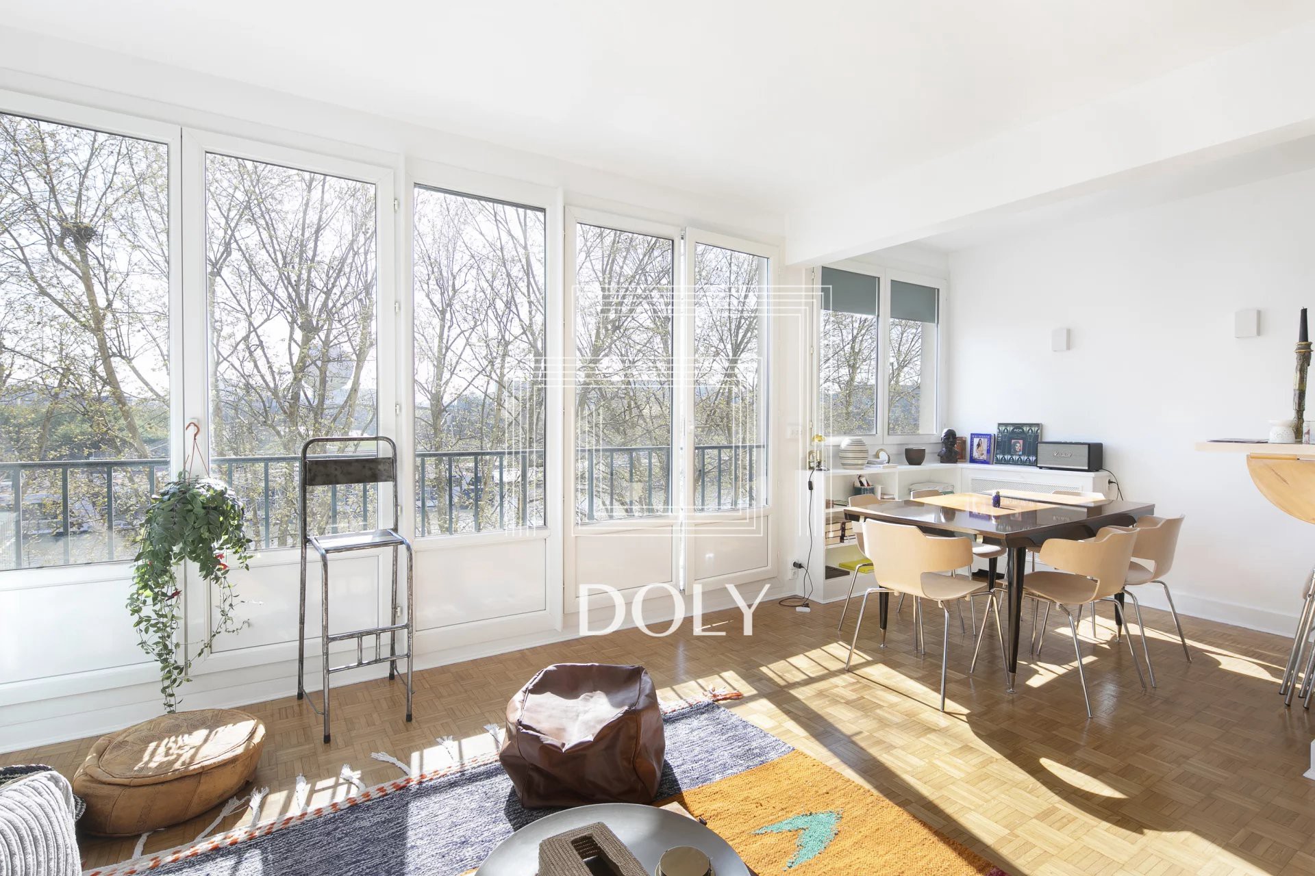 Appartement 3 pièces 66 m² / 75016 - Vue de l'espace de vie lumineux grâce à de grandes baies vitrées et à un espace pour un coin repas et un canapé.